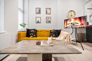 a living room with a yellow couch and a table at The Kensington Residence - Central London Base in London