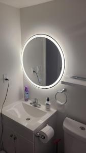 un bagno con un lavandino bianco e uno specchio di Two luxury bedrooms in the basement a Winnipeg Altre 17 foto
