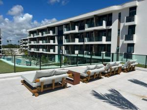 eine Reihe von Liegen vor einem Gebäude in der Unterkunft Flat Makia Beach Experience Muro Alto Porto de Galinhas in Porto De Galinhas