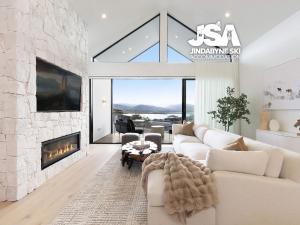 a living room with a couch and a fireplace at Willow Bay Chalet in Jindabyne