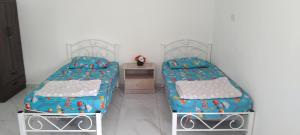 two beds sitting next to each other in a bedroom at Noor Roomstay in Taiping