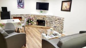 ein Wohnzimmer mit einem Steinkamin und einem TV in der Unterkunft 4-Bedroom Home by Downtown and Airport in Calgary