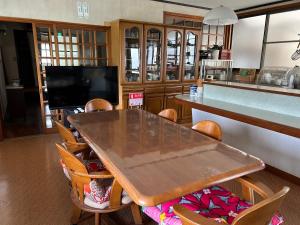 a dining room with a wooden table and chairs at Kouan 功庵 in Matsuyama