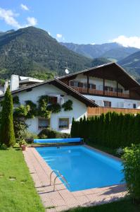 una villa con piscina di fronte a una casa di Pension Obergrundgut a Coldrano