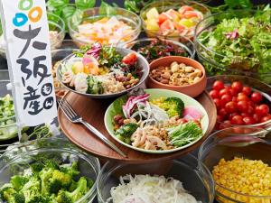 a buffet of food with bowls of vegetables and salads at APA Hotel & Resort Osaka Namba Ekimae Tower in Osaka