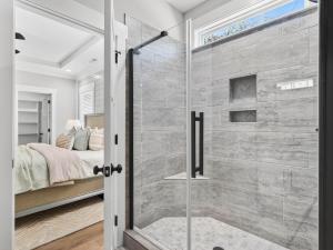 a glass shower in a bedroom with a bed at The Salty Ace in Oak Island +54 photos