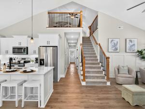 a kitchen and living room with white walls and a staircase at The Salty Ace in Oak Island
