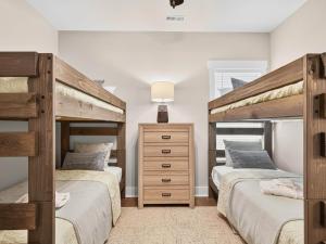 a bedroom with two bunk beds and a dresser at The Salty Ace in Oak Island