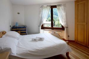 a white bed in a bedroom with a window at Residence des Alpes 302 appt - Chamonix All Year in Chamonix