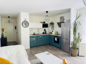 a kitchen with blue cabinets and a refrigerator at Appartement calme à Bayonne in Bayonne