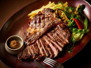 a steak and vegetables on a plate with a fork at APA Hotel & Resort Osaka Namba Ekimae Tower in Osaka