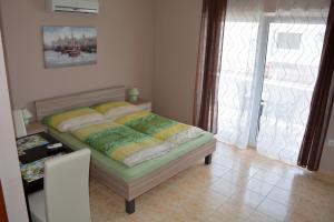 a small bedroom with a bed with a window at Apartments Viola Superior in Promajna