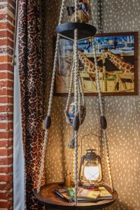 a hanging lamp with a giraffe on a wall at Hôtel des 4 continents - Le Mans in Saint-Saturnin