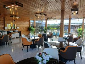 纳纽基Esiankiki Resort & Spa - Nanyuki的餐厅设有桌椅和木墙