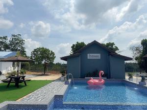 een zwembad met een roze zwaan voor een gebouw bij D' Ehsan Homestay & Chalet in Kuala Terengganu