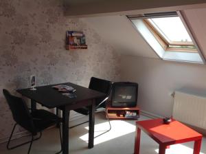 a living room with a table and a tv at B&B Op Kolderveen in Nijeveen