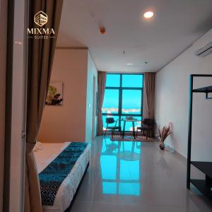 a hotel room with a bed and a dining room at Panoramic Seaview KK City The Shore at Mixma Suites in Kota Kinabalu