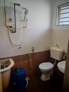 a bathroom with a shower and a toilet and a sink at Homestay Sakinah No 39 in Tanjung Malim +12 photos
