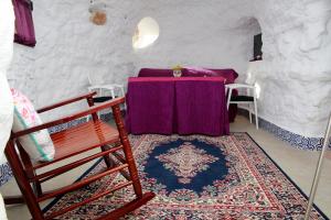 a room with a table and a chair and a rug at Balcones de Piedad in Los Balcones