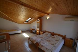 Un dormitorio con dos camas y techo de madera. en Guest House Olimpia, en Sozopol