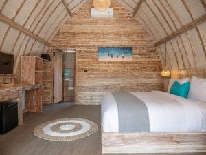 a bedroom with a bed in a wooden cabin at Gili Meno Escape - Adults Only in Gili Meno