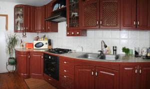 a kitchen with wooden cabinets and a sink at Sadiba Pri Dorogi in Kosiv