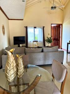 a living room with a couch and a glass table at Casa Pors Luxury Apartment with Security, Pool, & Gym in Liguanea