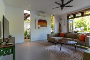 a living room with a couch and a table at Villa 6 - Private Pool WOW Holiday Homes in Pantai Cenang