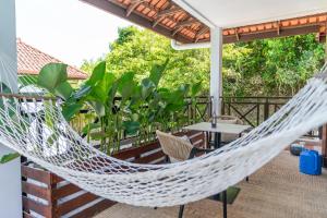 a hammock on the deck of a house at Villa 6 - Private Pool WOW Holiday Homes in Pantai Cenang