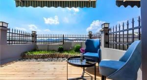 a patio with two chairs and a table and a fence at Echarm Hotel Qianxi High Speed Railway Station in Qianxi