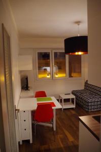 ein kleines Wohnzimmer mit einem Schreibtisch und einem Sofa in der Unterkunft Studio La Reine Astrid in Antibes