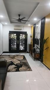 a living room with a ceiling fan and a front door at Lily Homestay in Alor Setar