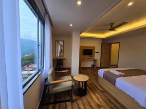ein Hotelzimmer mit einem Bett und einem großen Fenster in der Unterkunft The Pinecrest in Gangtok