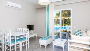 a living room with a table and chairs and a television at Kalina Hotel in Datca