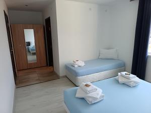 two twin beds in a room with a mirror at Victoria in Byala
