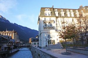 a large building next to a river in a city at Alpine Museum- Chamonix All Year in Chamonix
