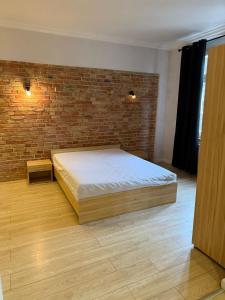 a bedroom with a bed and a brick wall at 1904 Studio in Świnoujście
