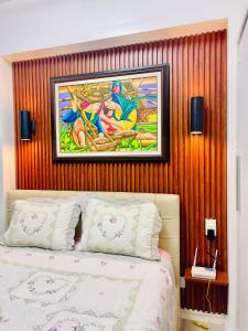 圣费尔南多Studio unit in San Fernando, The Hideaway的卧室配有床上方的绘画作品
