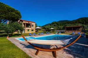 a pool with a hammock next to a house at Mediterraneo Luxury Suites Halkidiki in Vourvourou