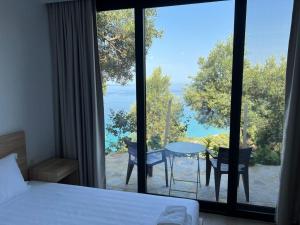 a bedroom with a large window with a table and chairs at Kulkoçe in Lukovë