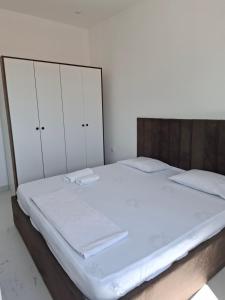 a bed with white sheets and white cabinets in a bedroom at Vila stockholm in Donji Štoj +3 photos