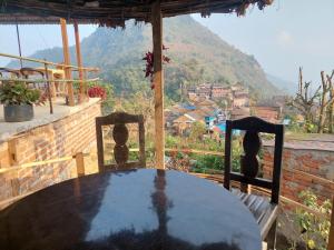 a table on a balcony with a view of a mountain at Culture home, home stay in Bandīpur +2 photos