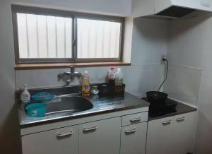 a kitchen counter with a sink and a window at 花迹民宿二号馆201 通天阁天王寺步行圈 心斋桥日本桥4分钟车程 in Osaka