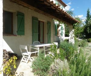 un patio con 2 sillas y una mesa frente a una casa en Vacances en Provence, en Pontevès