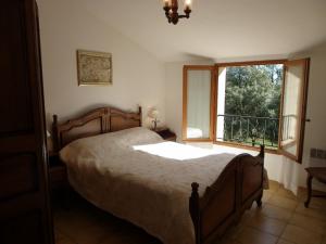 Un dormitorio con una cama grande y una ventana. en Vacances en Provence, en Pontevès