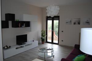 uma sala de estar com uma televisão, um sofá e uma mesa em Vieni in Calabria Casa Vacanze em Vibo Valentia