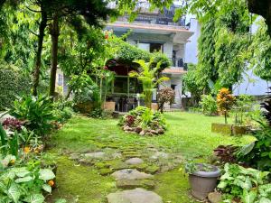 a garden in front of a large house at Cherry Garden Pokhara in Pokhara