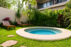 a large circular pool in the yard of a house at Aldea Zama - Lujo Natural en el Corazón de Tulum in Tulum