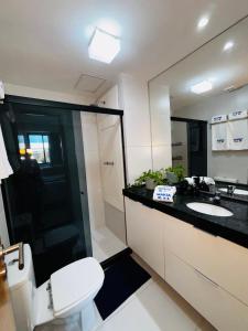 ein Badezimmer mit Toilette, Waschbecken und Spiegel in der Unterkunft Flat Makia Beach Experience Muro Alto Porto de Galinhas in Porto De Galinhas