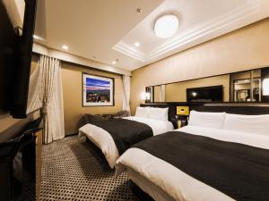 a hotel room with two beds and a flat screen tv at APA Hotel & Resort Osaka Namba Ekimae Tower in Osaka